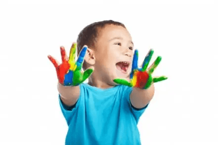 Criança com mãos coloridas de tinta